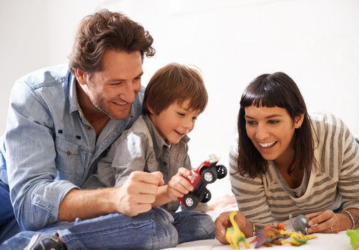 Never mind the mess, were making memories. happy parents playing with their son and his toys.