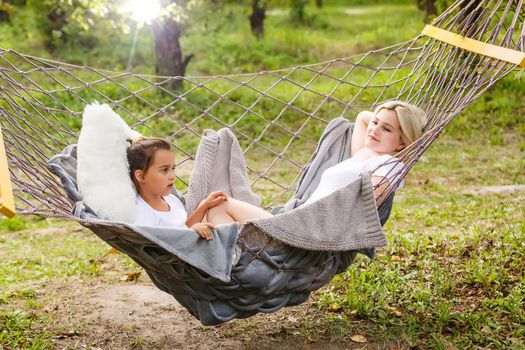 Mom and teenage daughter lying in a hammock
