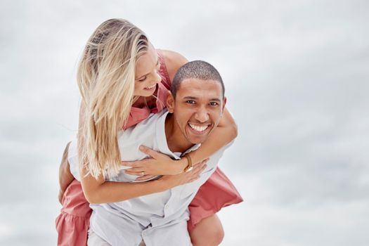 Love, freedom and couple embrace at beach, happy and relax on summer vacation together. Portrait of interracial man and woman enjoy playful relationship outdoors in nature, having fun bonding on trip