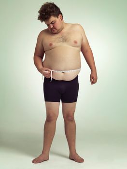 Maybe Im gluten intolerant. a man measuring his overweight belly.