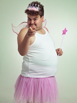 I see you. An overweight man in a pink fairy costume pointing at the camera.