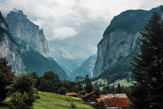 Lauterbrunnen valley, Switzerland. Swiss Alps. Cozy small village in mountains. Forest, rocks, clouds and green meadows