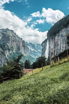 Lauterbrunnen valley, Switzerland. Swiss Alps. Village in mountains. Waterfall and green meadows