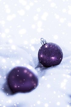 Violet Christmas baubles on fluffy fur with snow glitter, luxury winter holiday design background