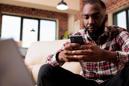 Male freelancer browsing internet on smartphone