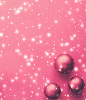 Christmas baubles on pink background with snow glitter, luxury winter holiday card