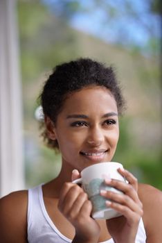 Coffee can make any day a good day. young woman enjoying a cup of coffee in the morning.
