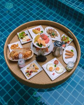 Floating breakfast in the swimming pool , floating breakfast in the pool with bread eggs and fruit