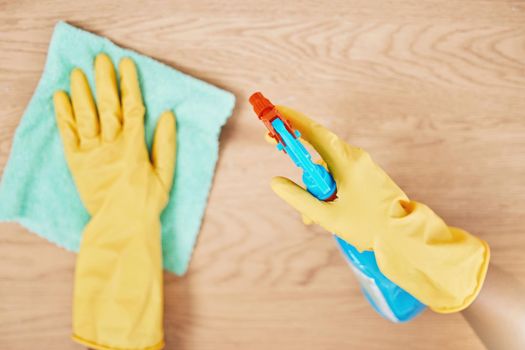 Cleaning spray, glove hands and wipe table, counter and wood surface for housekeeping service at home. Above of maid, janitor and cleaner dust cloth chore, furniture shine and chemical bottle product