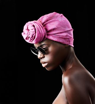 Style is a way of saying who you are without having to speak. Studio shot of a beautiful woman wearing a headscarf against a black background.