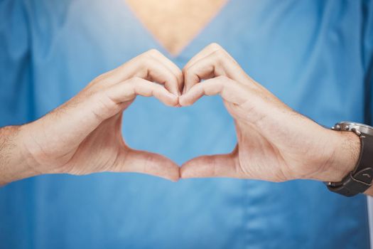 Doctor or nurse make heart sign, with hands to show care or compassion. Woman worker in healthcare show love icon with fingers, as expression of love for their job or wellness of patients.
