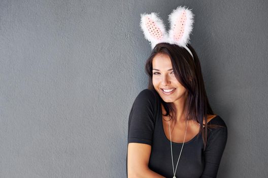 Playing it coy for the boys. Portrait of a gorgeous brunette wearing bunny ears.
