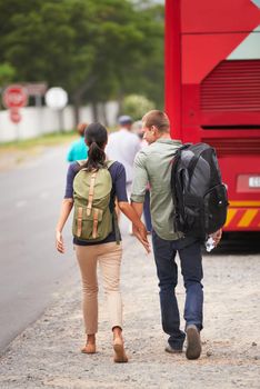 There wish was to make memories all over the world. Rear view shot of a travelling couple walking towards their bus.