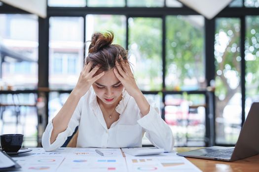 portrait of a women employee shows an anxious and stressed face from working on paperwork