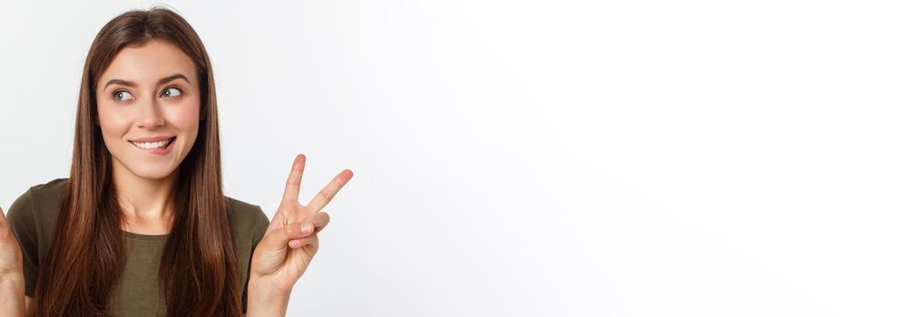 Young woman showing two fingers, positive or peace gesture, on white.