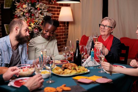 Smiling woman proposing christmas toast at family gathering