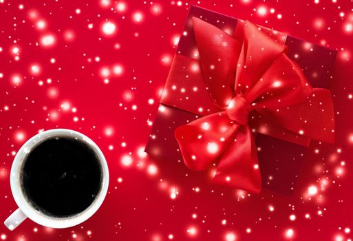 Winter holiday gift box, coffee cup and glowing snow on red flatlay background, Christmas time present surprise