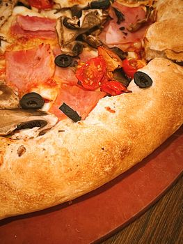 Pizza capriciosa with cheese stuffed crust in pizzeria, food