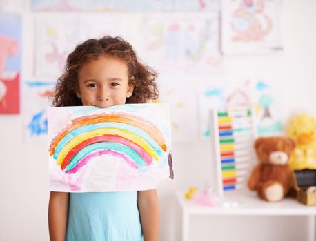 Dont you just love the colors. a little girl holding up a picture she painted of a rainbow.