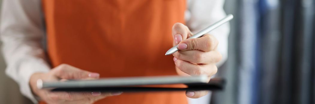 Tablet with stylus in female hands in uniform closeup