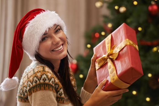 I bet its awesome. Portrait of an attractive young woman receiving a gift on Christmas morning.
