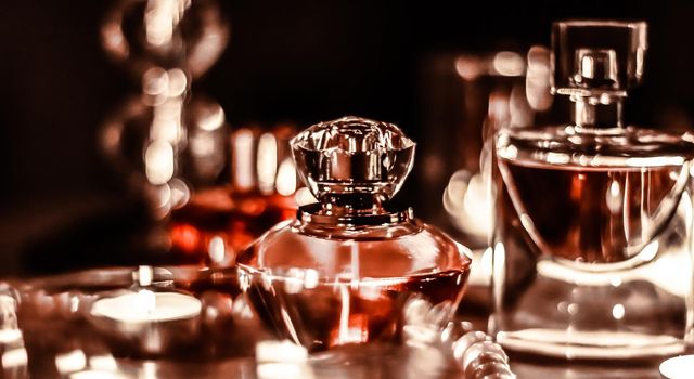 Perfume bottle and vintage fragrance on glamour vanity table at night, pearls jewellery and eau de parfum as holiday gift, luxury beauty brand present