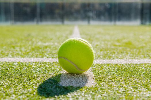 yellow tennis ball in court of green turf