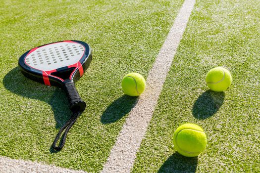 paddle racket and balls on artificial grass