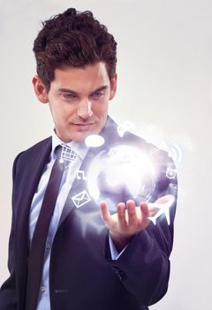 Hes got the future in his hands. A handsome young businessman holding a digital generated globe of information.