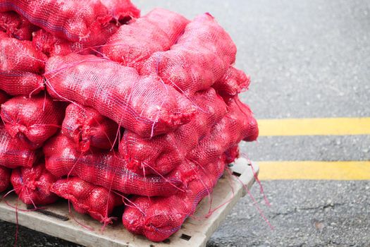 stack of red onion in bags