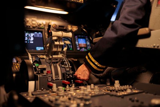 Woman airliner pushing dashboard buttons in plane cockpit