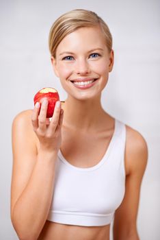 My body will thank me later. A portrait of a beautiful young woman eating a delicious red apple.