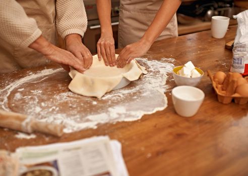 Theres an art to this. A cropped view of hands working the dough while baking in a kitchen.