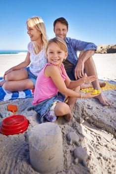 Castles in the sand. a happy young family at the beach.