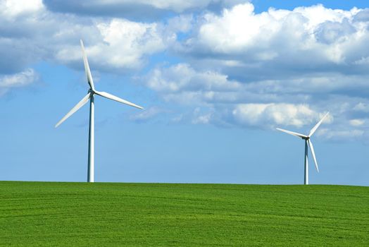 Creating energy with the wind. wind turbines on a grassy field.