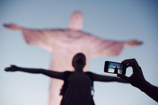 Capturing the moment. A cropped shot of a woman imitating the pose of Christ the Redeemer in Rio.
