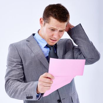 Facing an uncertain future. A businessman holding a pink slip terminating his employment.