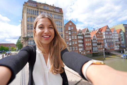 Beautiful young woman taking selfie photo with smartphone in Hamburg, Germany