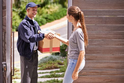 When she expects excellence she knows hell deliver the goods. a woman shaking hands with a friendly delivery man.