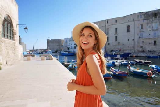 Young tourist woman in the ancient town and port of Monopoli, Apulia, Italy
