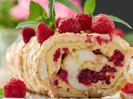 Baked meringue roll with cream and fresh red raspberry 