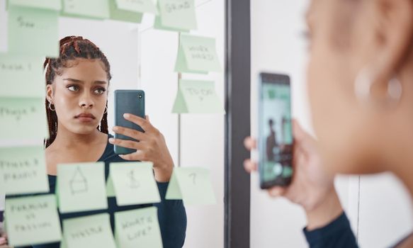 Sad, anxiety and woman at mirror with phone for pensive reflection photograph for social media. Depressed black girl with frustrated and unhappy face thinking of self esteem problem in distress.