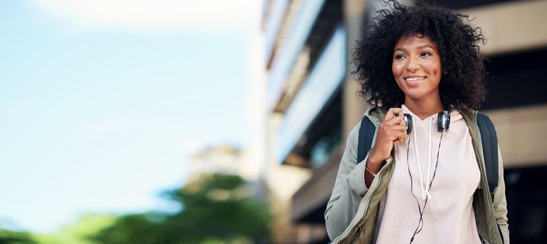 portrait african american woman smiling happy in city street wearing headphones