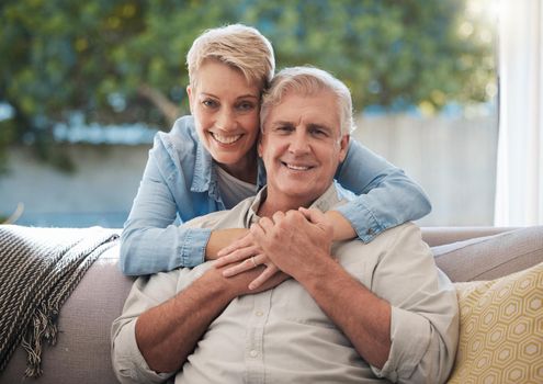 Couple, love and senior man and woman sitting on a sofa in the living room and enjoying retirement. Portrait of an elderly male and female pensioner in a home to relax and spend time together
