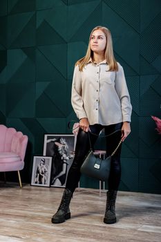 A beautiful woman in a white shirt and leather leggings and in stylish shoes. New collection of women's shoes with genuine leather