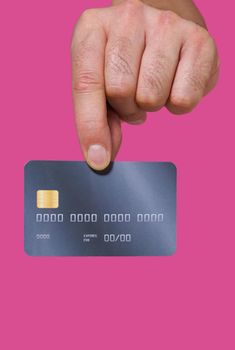Close up, man hand holding credit, debit bank card with two fingers. Male hand with credit card. Plastic banking card in man hand isolated on pink background