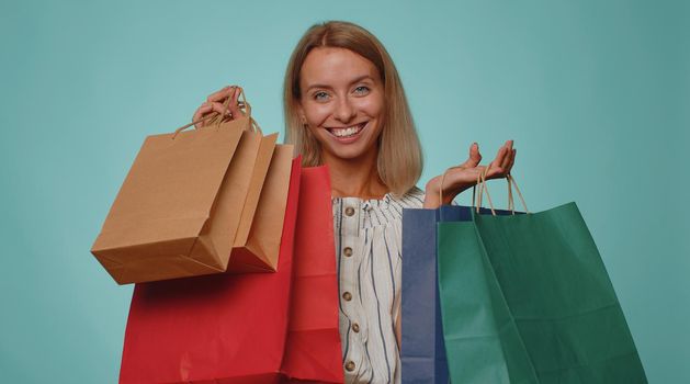 Happy tourist woman showing shopping bags, advertising holidays discounts, amazed with low prices