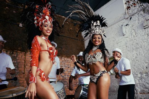 Making the music come alive. Portrait of two beautiful samba dancers and their band.