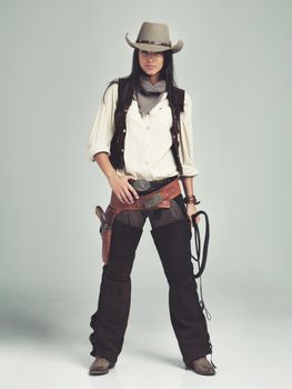 Im the sheriff around these parts...Full-length shot of an attractive young woman in cowboy attire.