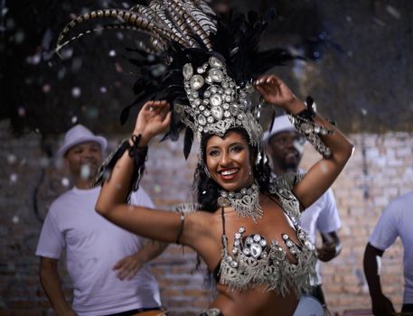 Glamourous dancing queen. a beautiful samba dancer performing in a carnival with her band.